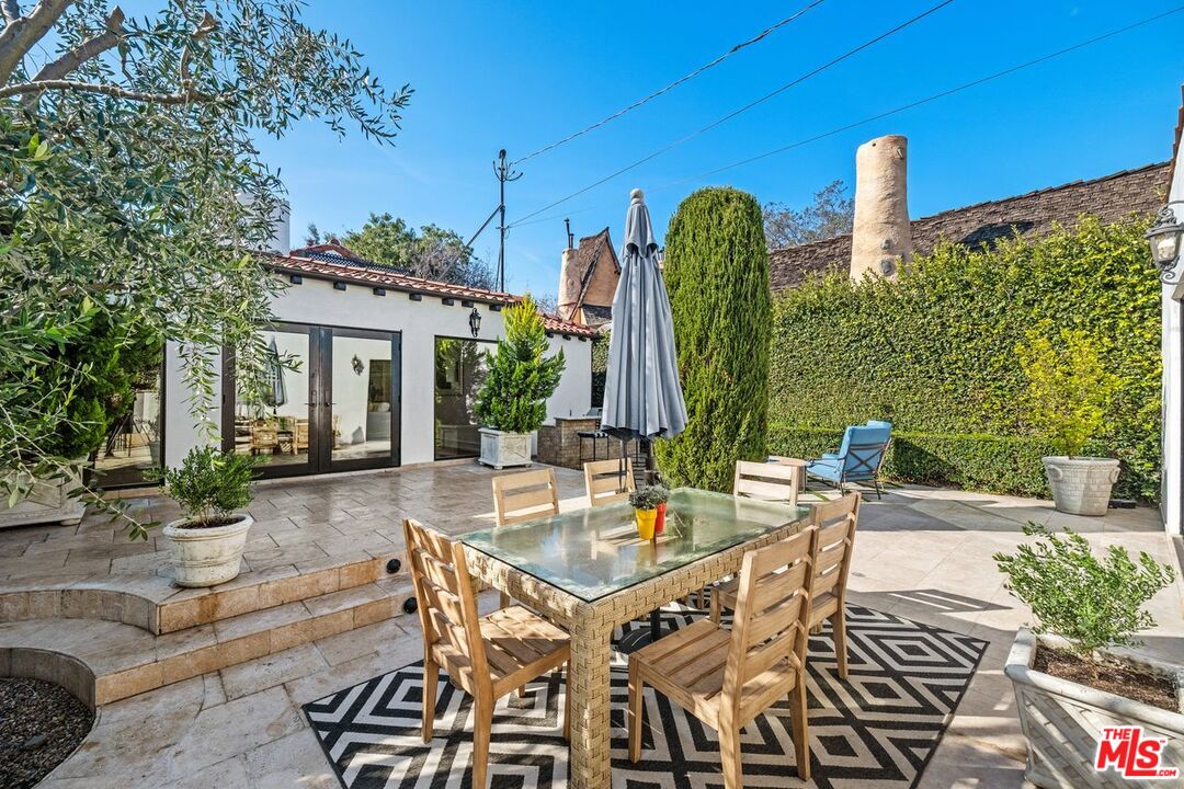 514 Walden Drive Beverly Hills, CA 90210 - Photo 47 of 59 a view of a patio with table and chairs potted plants and a large tree