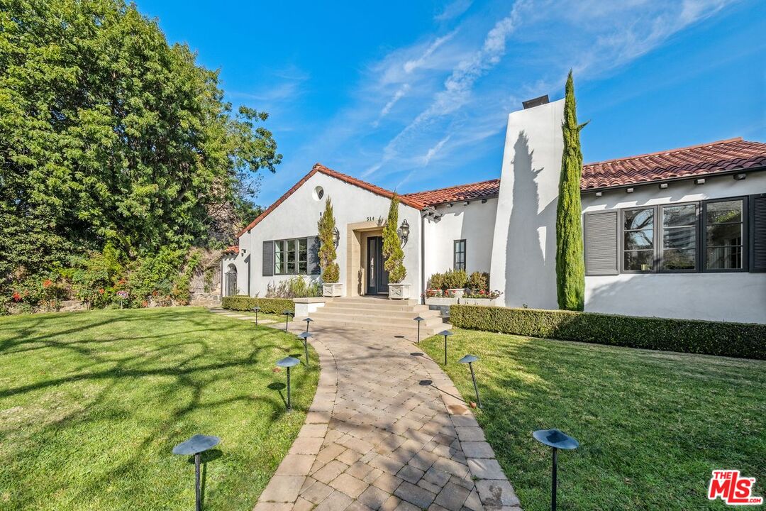 514 Walden Drive Beverly Hills, CA 90210 - Photo 9 of 59 a front view of a house with a yard