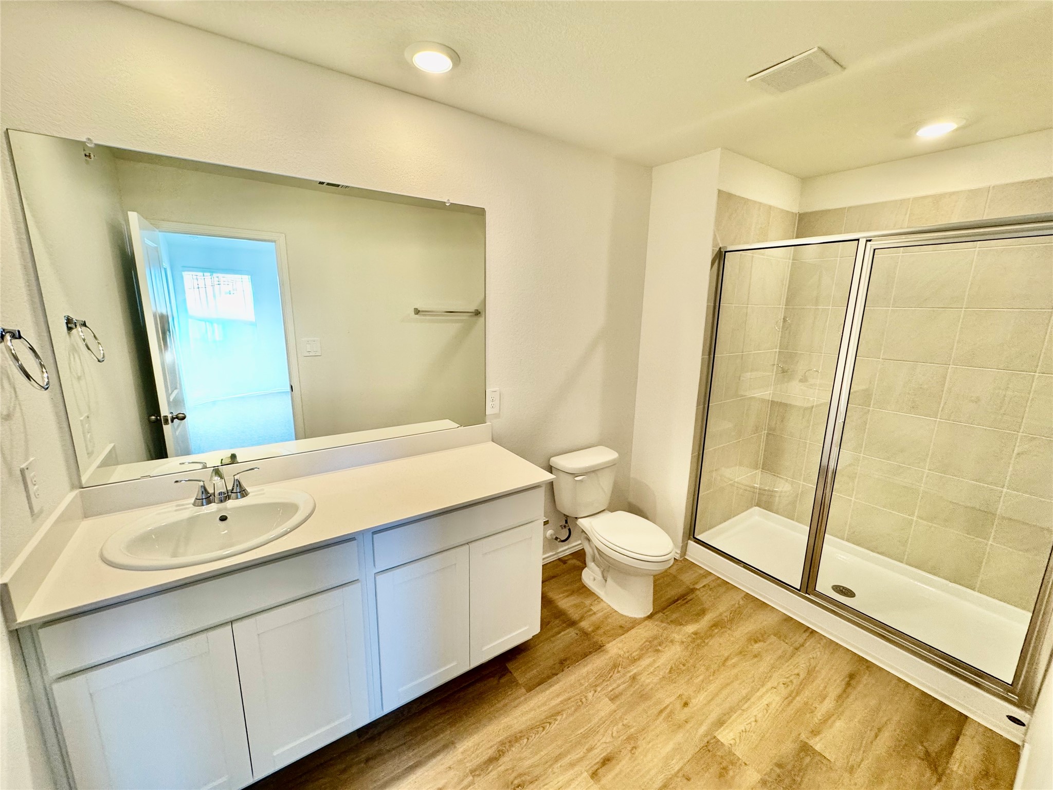 105 Calcite Road, Unit 5 Kyle, TX 78640 - Photo 3 of 6 Bathroom featuring vanity, a stall shower, light wood-style flooring, and recessed lighting