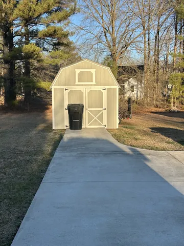 a view of a white house with a large trees