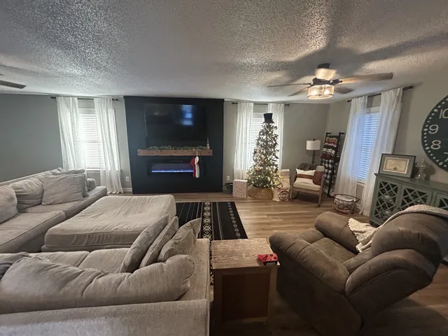 a living room with furniture a fireplace and a flat screen tv