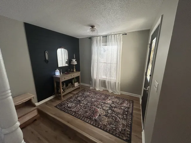 a view of a livingroom with wooden floor and a window