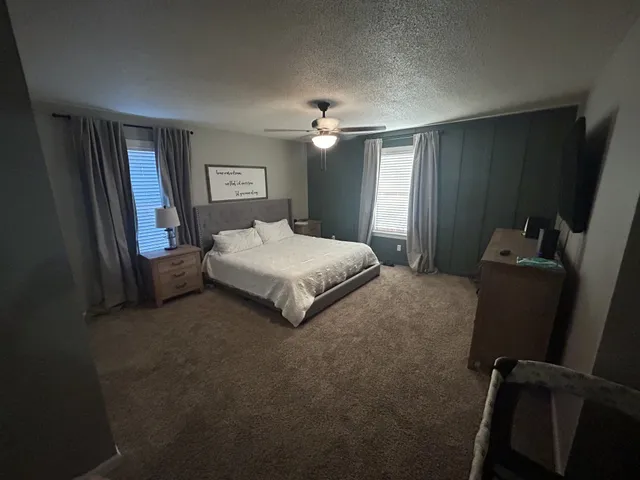 a spacious bedroom with a bed and a chandelier