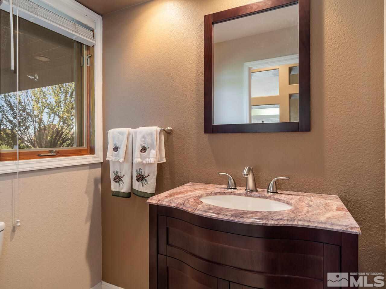 7210 Cheltenham Way Reno, NV 89502 - Photo 14 of 26 a bathroom with a granite countertop sink and a mirror