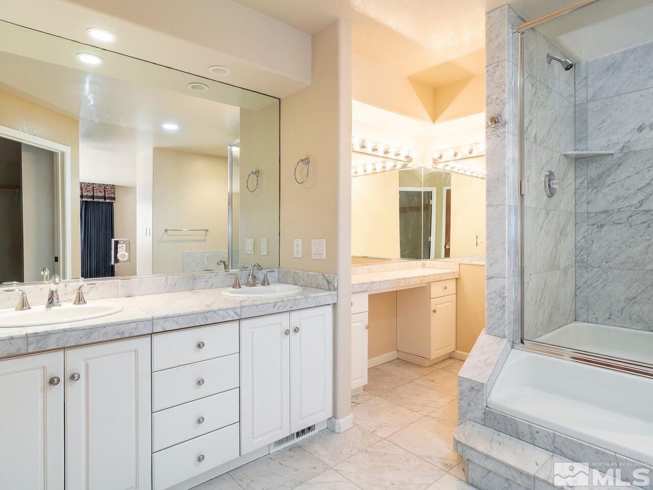 7210 Cheltenham Way Reno, NV 89502 - Photo 18 of 26 a spacious bathroom with a double vanity sink a large mirror and a bathtub