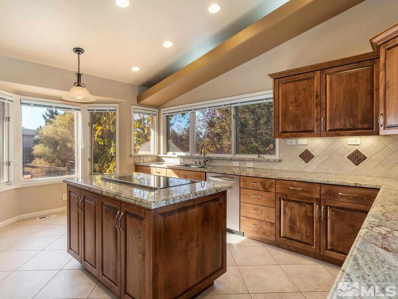 7210 Cheltenham Way Reno, NV 89502 - Photo 5 of 26 a kitchen with stainless steel appliances granite countertop a stove a sink and a microwave