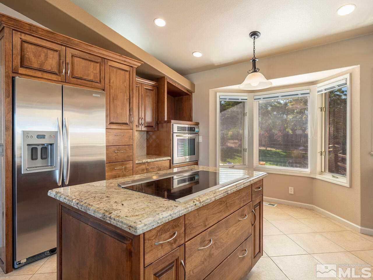 7210 Cheltenham Way Reno, NV 89502 - Photo 6 of 26 a kitchen with stainless steel appliances granite countertop a sink and a refrigerator