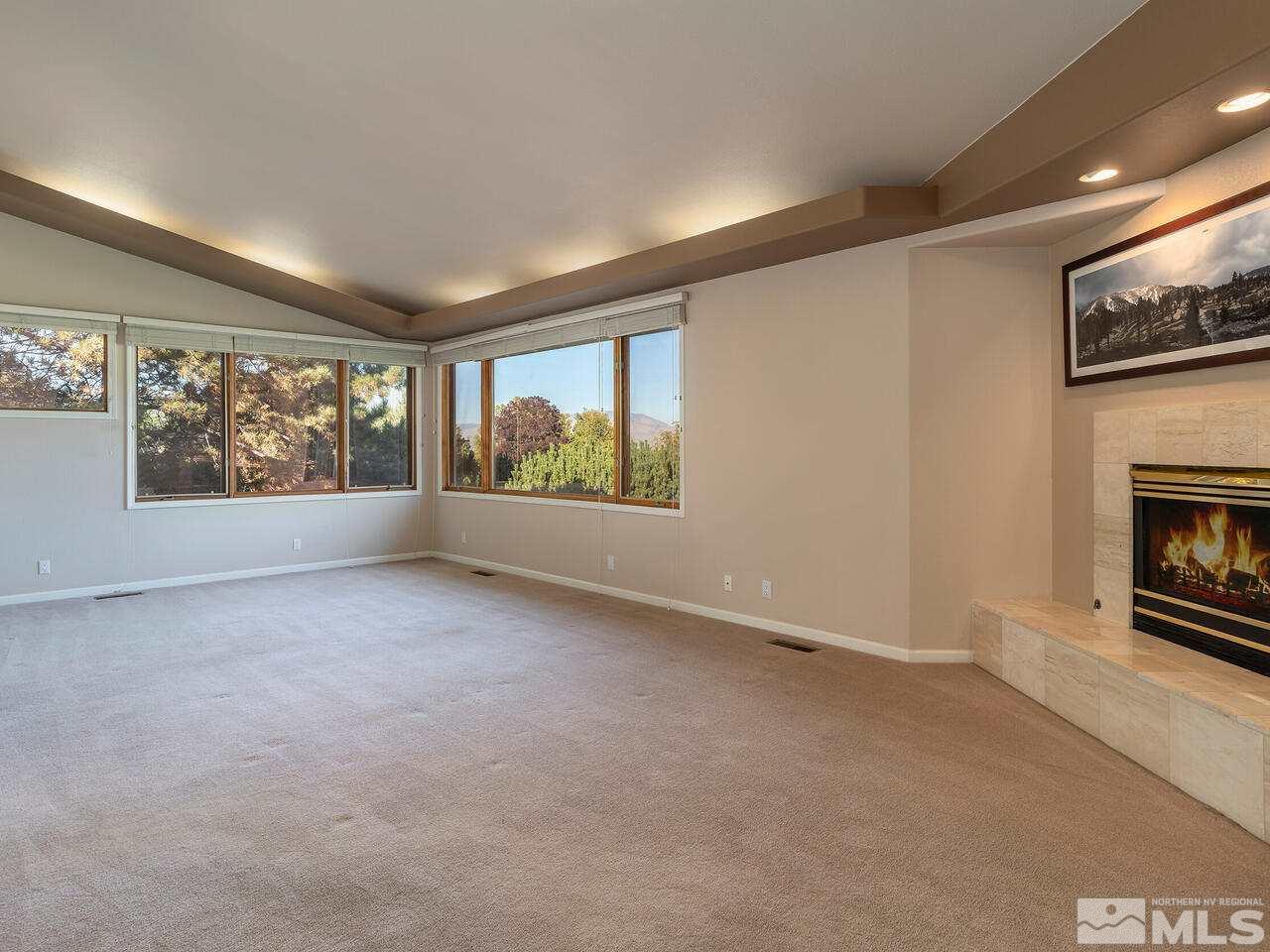 7210 Cheltenham Way Reno, NV 89502 - Photo 8 of 26 a view of an empty room with a window and fireplace