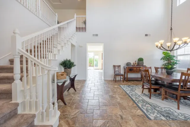 a dining room with furniture a potted plant and a window