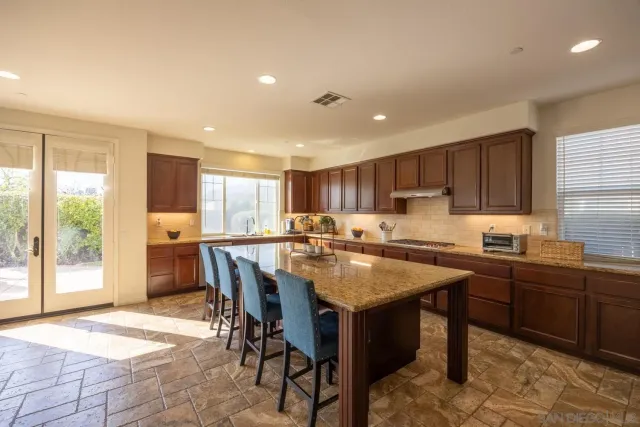 a kitchen with stainless steel appliances granite countertop sink stove and refrigerator