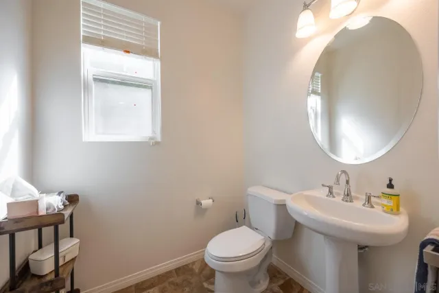 a bathroom with a sink a toilet and a large mirror