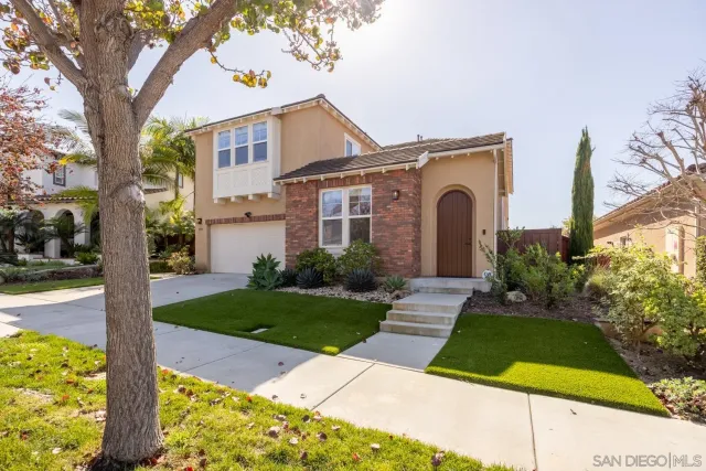 a front view of a house with yard and green space