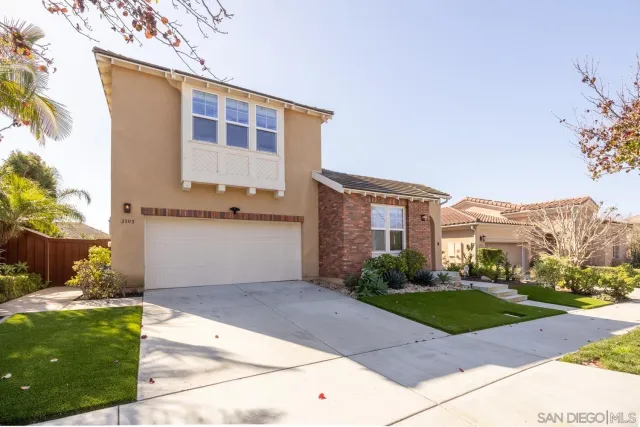 a front view of a house with a yard and potted plants