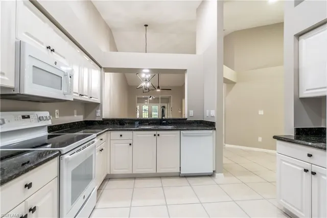 a large kitchen with granite countertop a sink a stove and cabinets