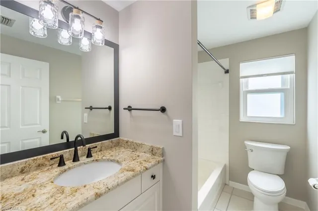 an empty room with windows and ceiling fan