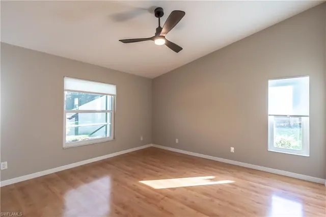a view of a room with wooden floor and a ceiling fan