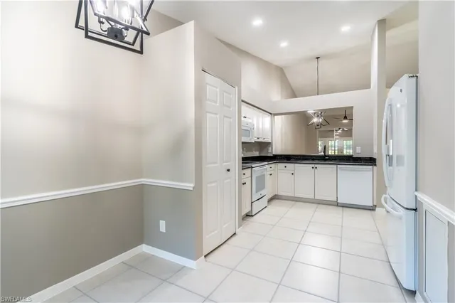 a large white kitchen with a sink and refrigerator