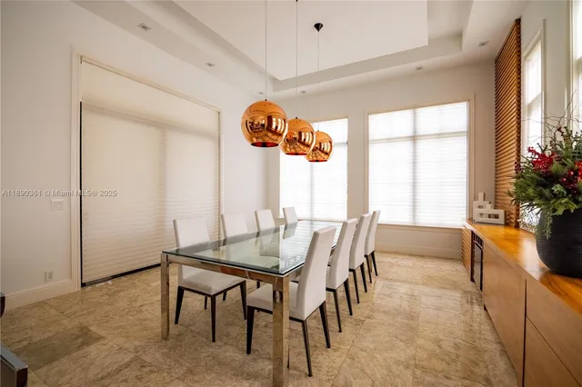 a dining room with granite countertop a table chairs and a view of kitchen