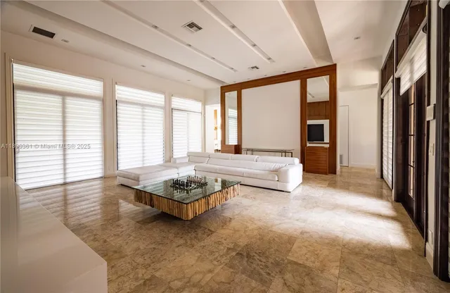 a living room with a bed furniture and next to a window