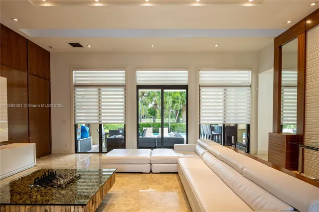 a living room with furniture and floor to ceiling windows