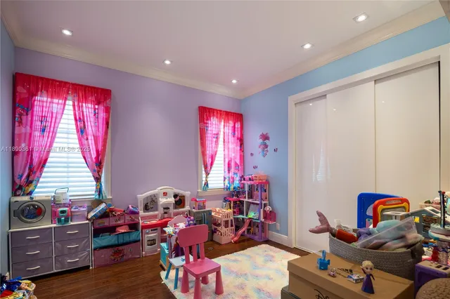 a view of a white house next to a yard with big trees