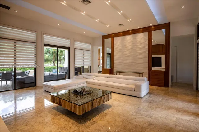 a living room with stainless steel appliances furniture a rug and a window