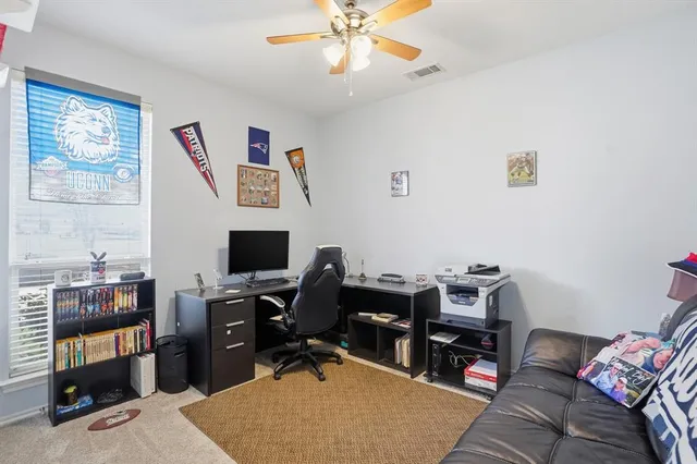 a view of a workspace with furniture and a window