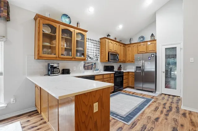 a kitchen with stainless steel appliances a stove sink microwave and cabinets