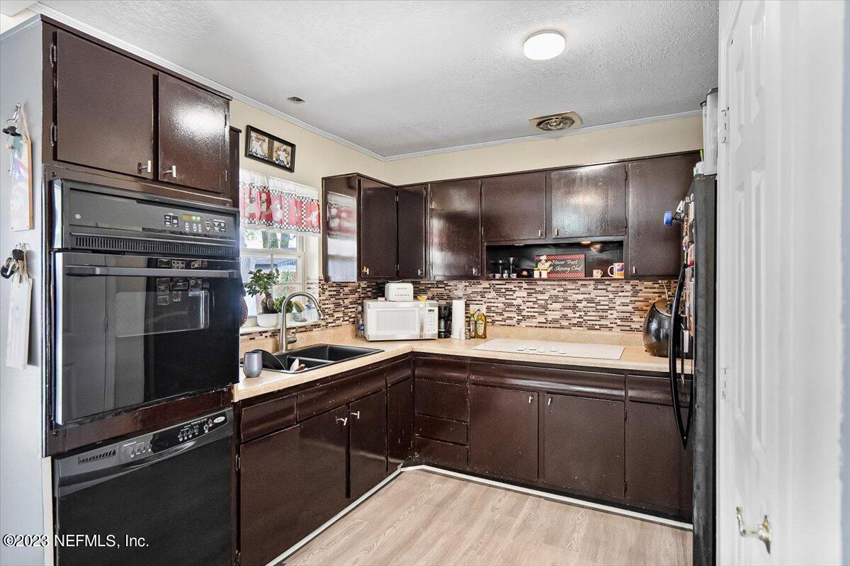 7240 Adele Court Jacksonville, FL 32277 - Photo 11 of 27 a kitchen with stainless steel appliances kitchen island granite countertop a refrigerator and a sink
