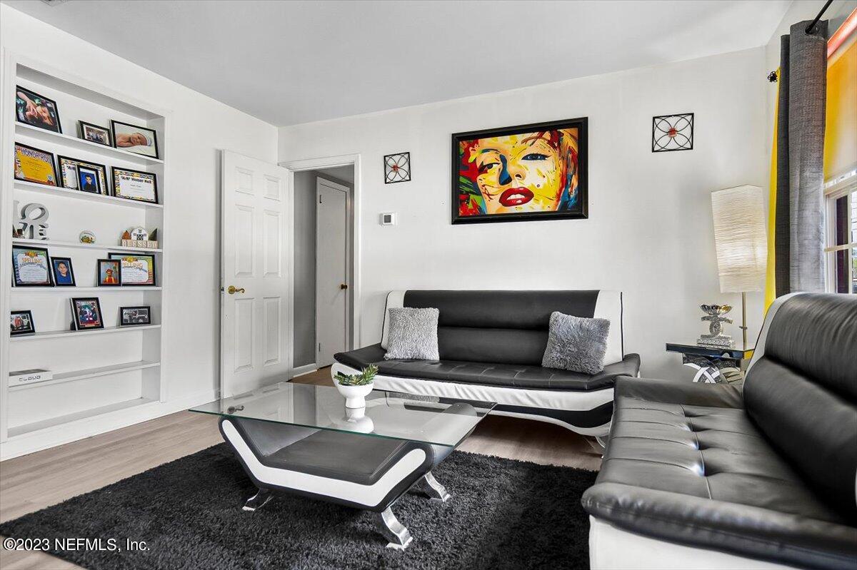 7240 Adele Court Jacksonville, FL 32277 - Photo 4 of 27 a living room with furniture a rug and wall paintings