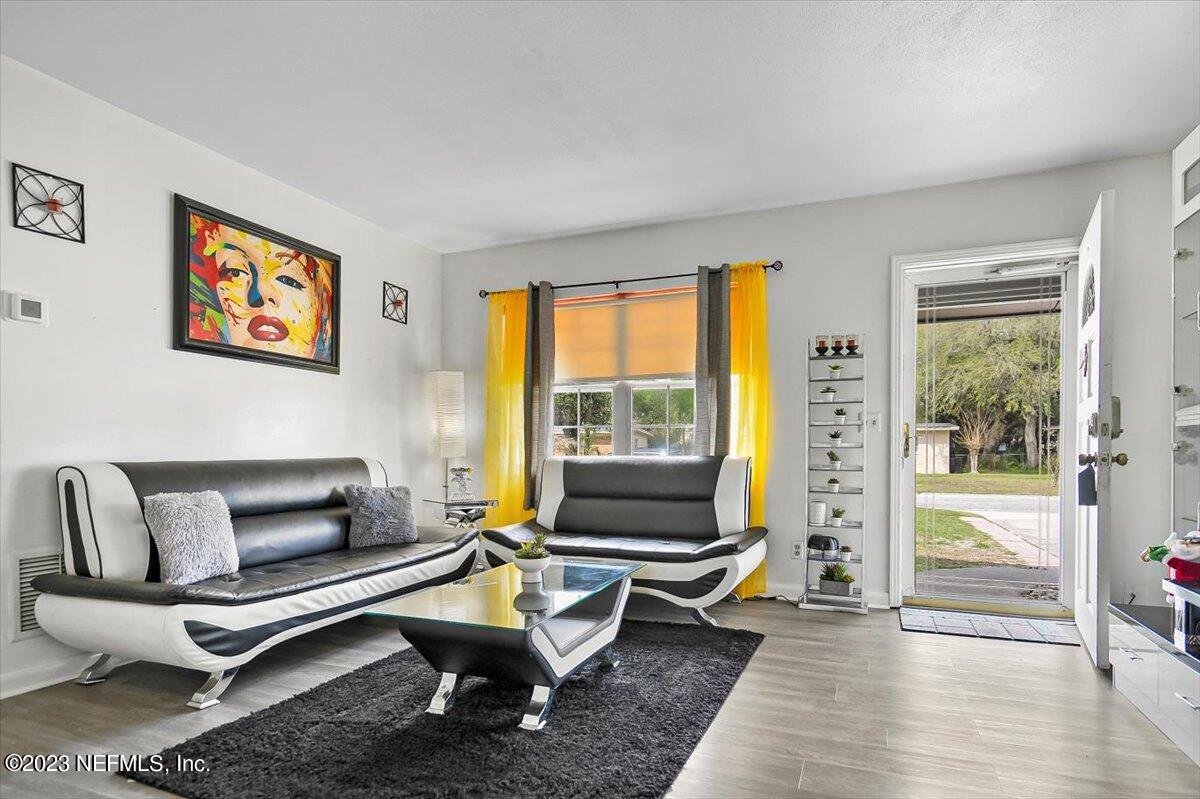 7240 Adele Court Jacksonville, FL 32277 - Photo 7 of 27 a living room with furniture a rug and a floor to ceiling window