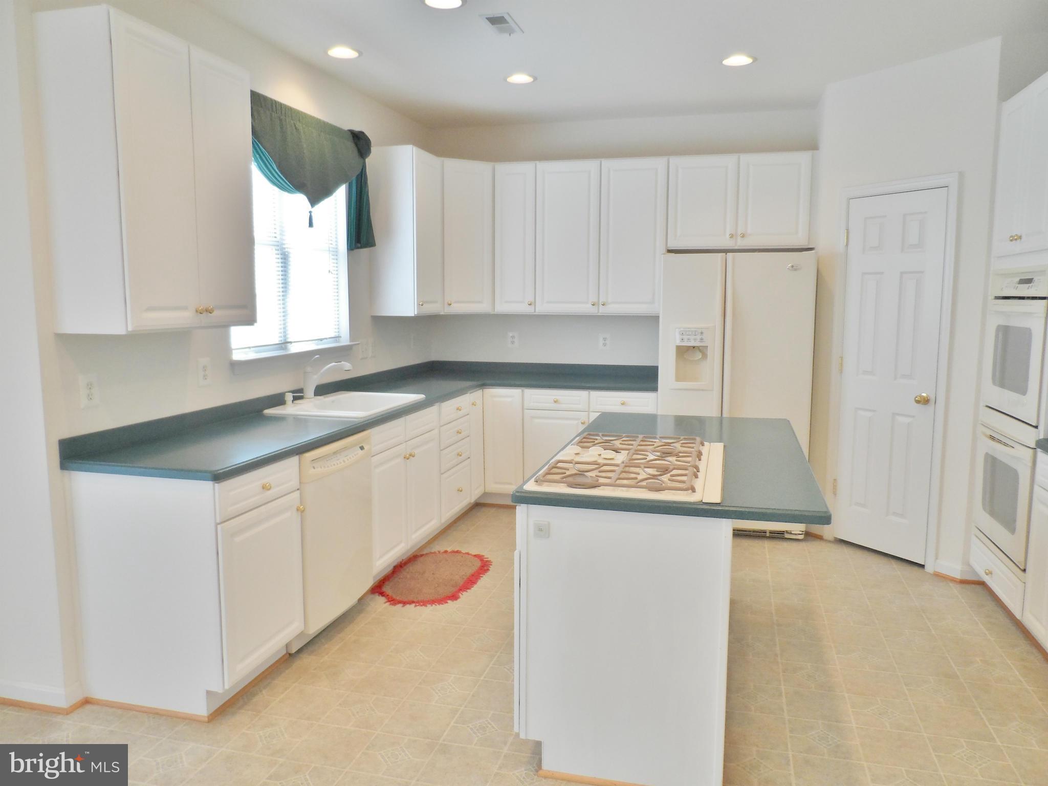 6281 Willowfield Way Springfield, VA 22150 - Photo 8 of 28 a kitchen with a sink a stove a refrigerator and white cabinets