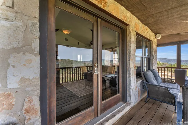 a view of a balcony with furniture and floor to ceiling window