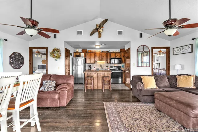 a living room with furniture kitchen view and a chandelier