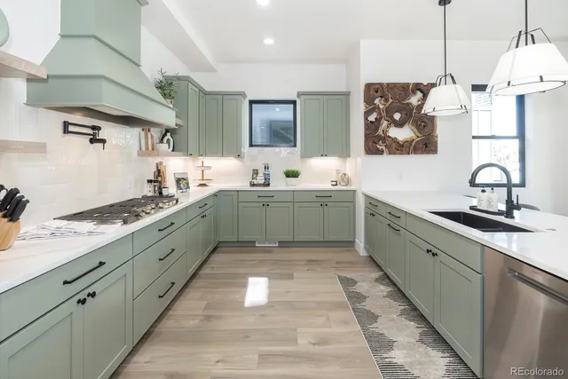 a large kitchen with stainless steel appliances granite countertop a sink stove and refrigerator