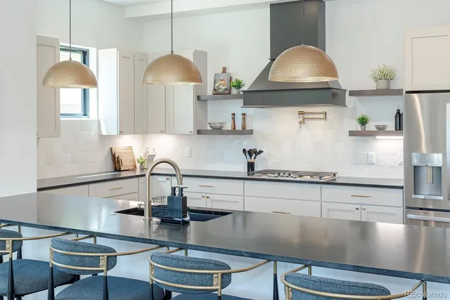 a kitchen with sink a stove and chairs