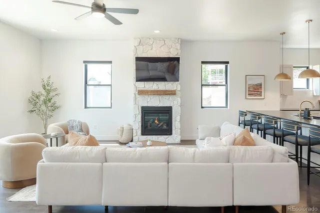 a living room with furniture a fireplace and a chandelier