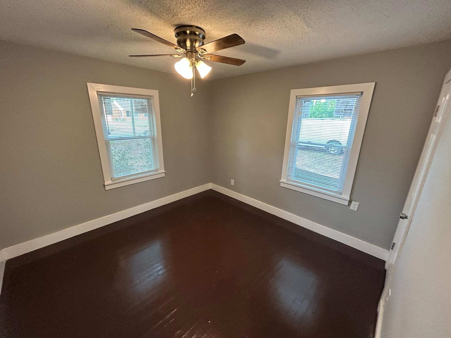 4824 Hodge Road Memphis, TN 38109 - Photo 3 of 6 Spare room with ceiling fan, a textured ceiling, and dark hardwood / wood-style flooring