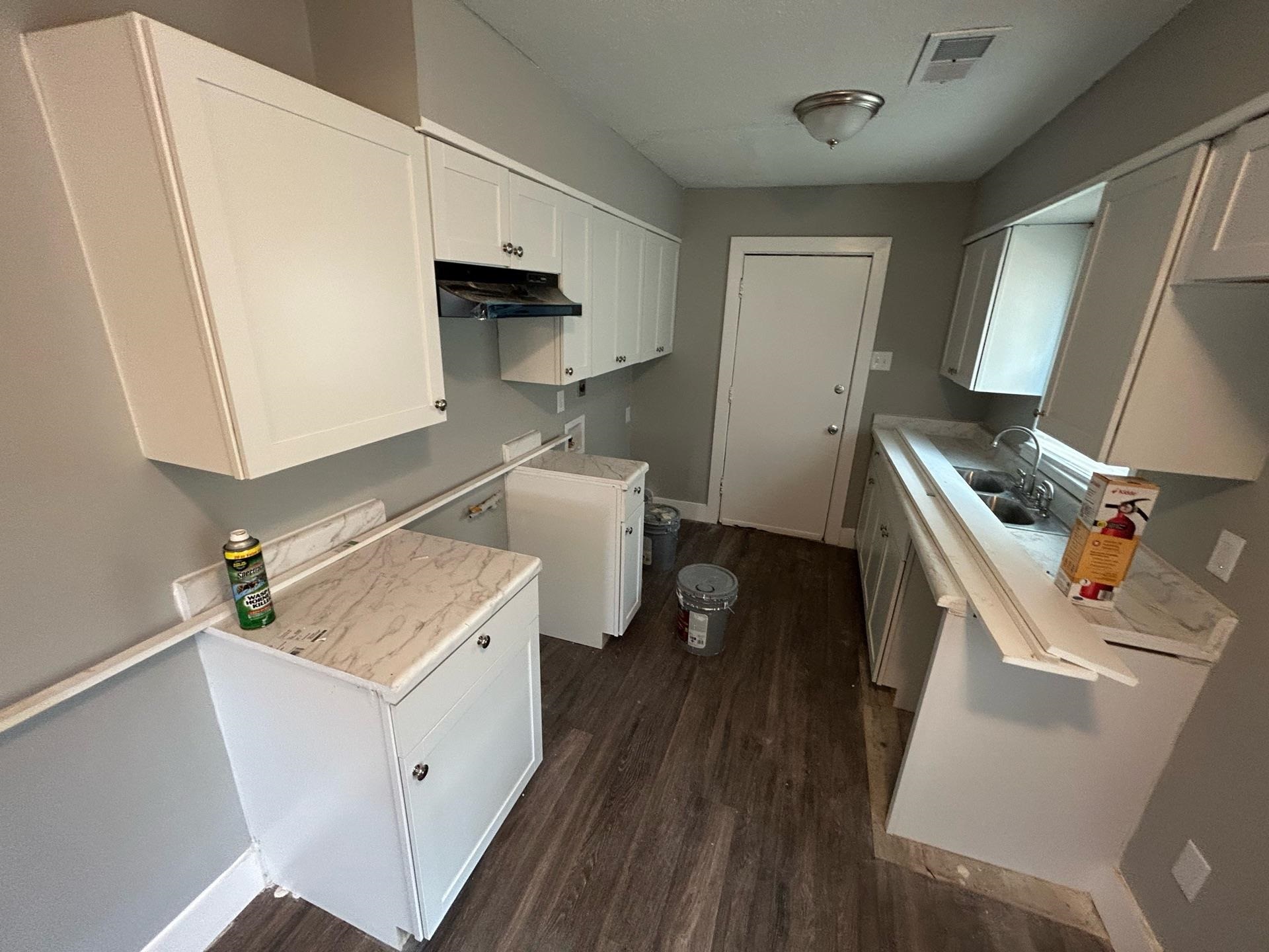 4824 Hodge Road Memphis, TN 38109 - Photo 6 of 6 Kitchen with white cabinetry and dark hardwood / wood-style flooring