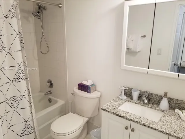 a bathroom with a granite countertop toilet sink and bathtub
