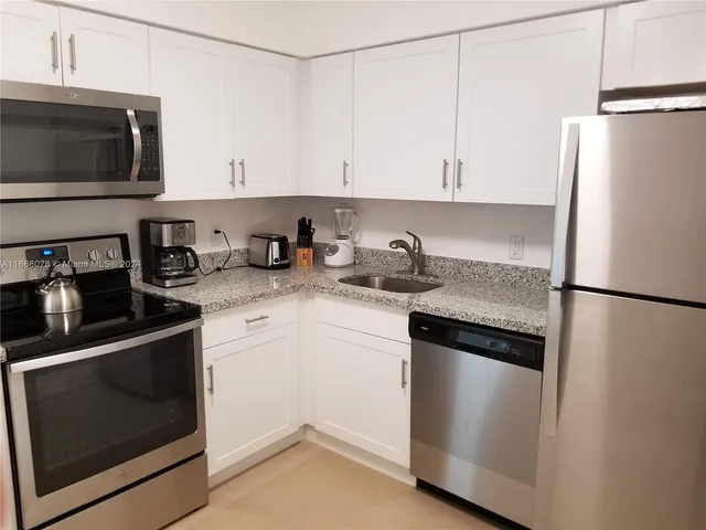 a kitchen with a refrigerator stove and white cabinets