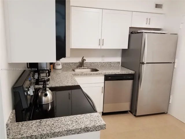 a kitchen with a refrigerator and a sink