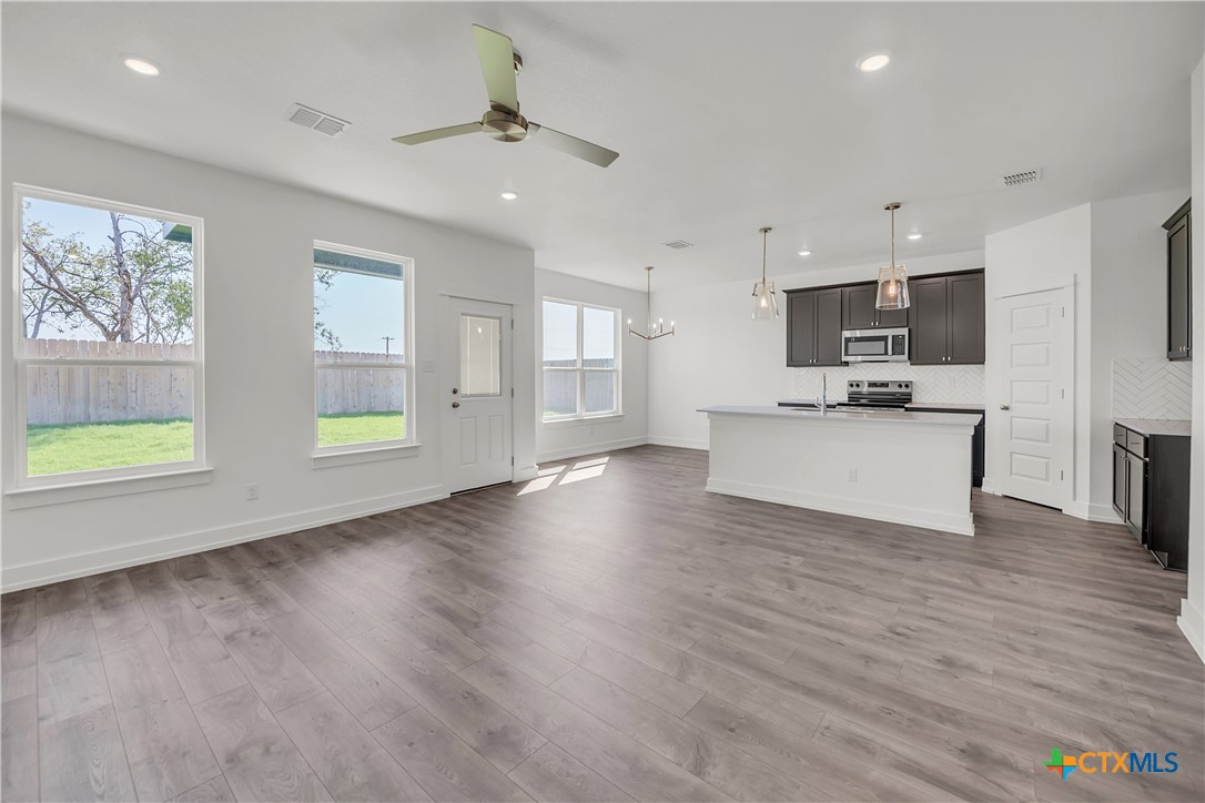1209 Peppermint Drive Temple, TX 76501 - Photo 6 of 17 a view of kitchen with microwave a stove and wooden floor