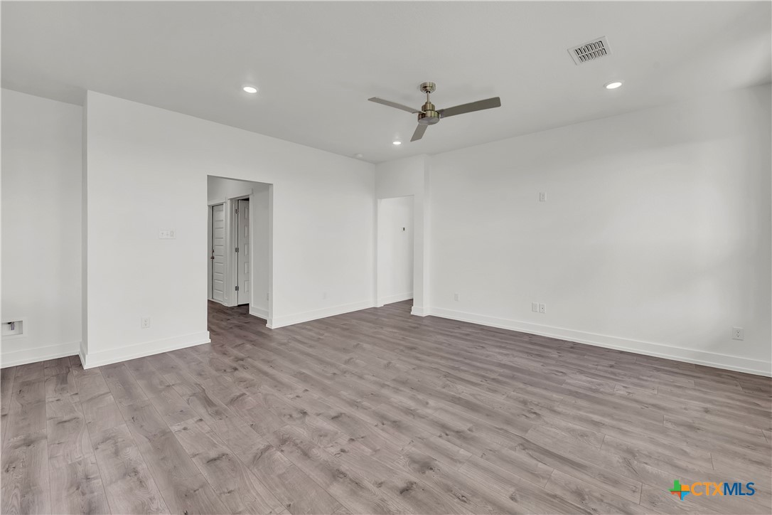 1209 Peppermint Drive Temple, TX 76501 - Photo 9 of 17 a view of an empty room with wooden floor and ceiling fan