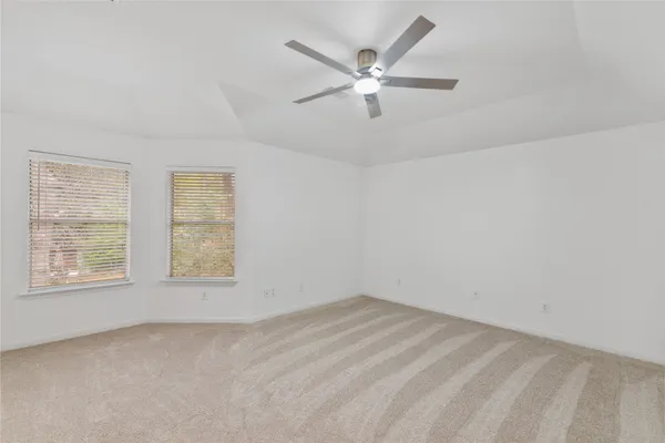 an empty room with a window and a fan