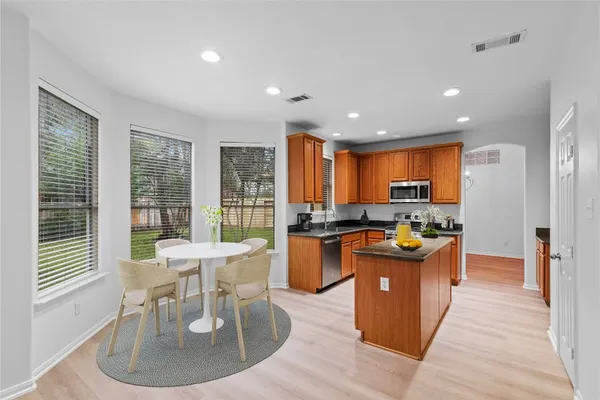 a kitchen with stainless steel appliances granite countertop a stove and a wooden floors