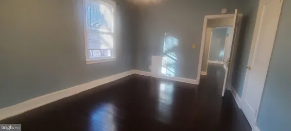 a view of a small space with wooden floor and a window