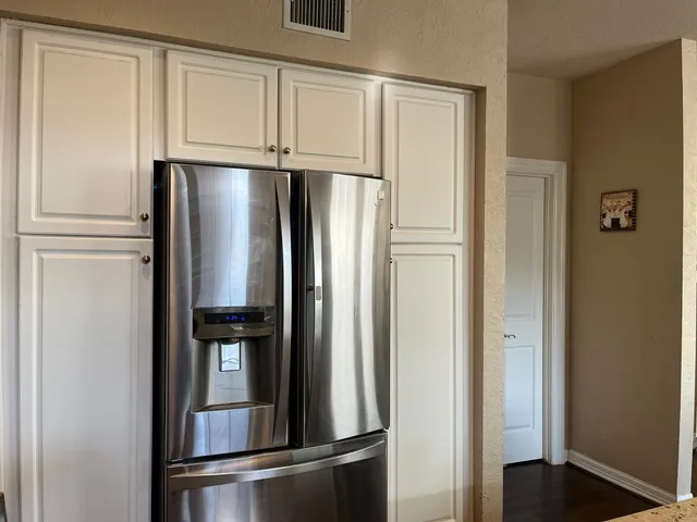 a metallic refrigerator freezer sitting in a kitchen
