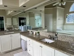 a bathroom with double sink and a mirror
