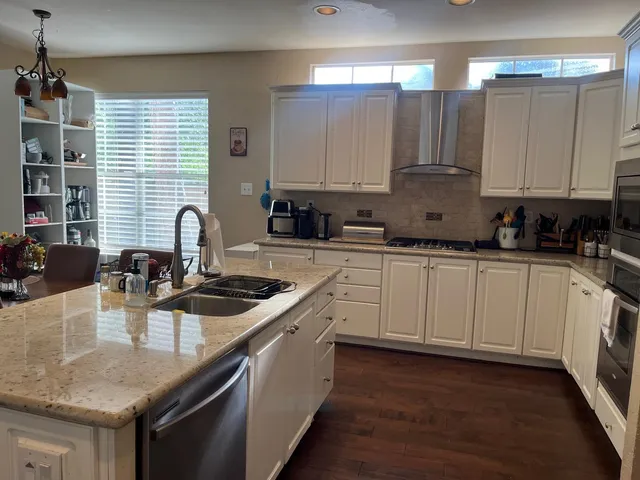 a kitchen with stainless steel appliances granite countertop a sink stove and cabinets